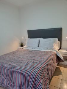 里奥加耶戈斯Hermoso departamento con patio en Rio Gallegos的一间卧室配有带条纹被子的床