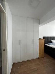 普库萨纳Apartamento Mar Naplo的卧室配有白色橱柜,位于床边