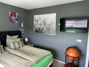 哈纳弗约德尔Eskivellir 11的卧室配有一张床,墙上挂有两张照片