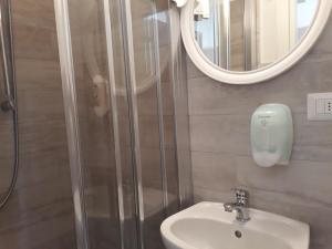 里米尼Hotel Villa Mon Reve的带淋浴、盥洗盆和镜子的浴室