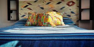 康考迪亚DCH Hostel Backpaquers的床上有色彩缤纷的枕头