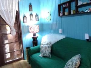 特拉曼达伊Pousada Atlântica stay home的一间卧室配有绿色的床和一盏灯