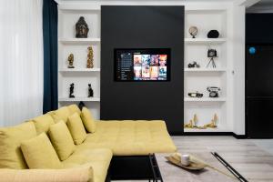奥拉迪亚Backyard Jacuzzi House的客厅设有黄色沙发和电视