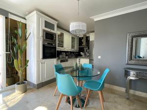 阿吉内金海滩Selena Luxury Monte Carrera的厨房配有玻璃桌和蓝色椅子