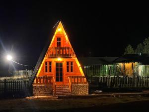 LeskovikCamping Farm Shelegur的一间晚上有灯的屋顶的小房子