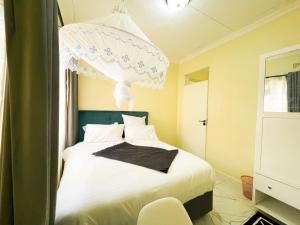 MzuzuThe N3 Suites的一间卧室配有一张带天蓬的白色床