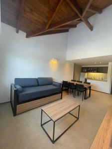 卡薇亚惠Villa Maihue departamentos de montaña - Caviahue的客厅配有蓝色的沙发和桌子