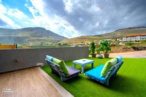 马格达拉Yalarent Melody- Suites with privat pools的绿色草坪上带桌椅的庭院
