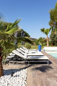 圣卡纳LES LODGES TAIZEN, séjour SPA- sans enfants的游泳池旁的一排白色躺椅