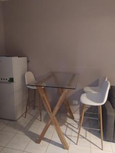 都拉斯1+1 family flat with balcony的玻璃桌、两把椅子和冰箱