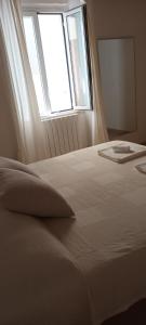 利沃诺Il porto di Ale e Kat的卧室配有白色的床和窗户