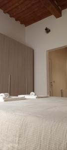 利沃诺Il porto di Ale e Kat的卧室设有白色的床和木制天花板。