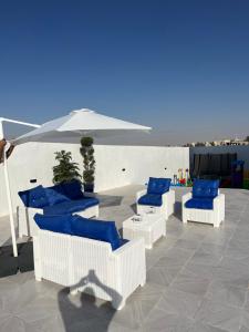安曼Amman villa的庭院里摆放着一组蓝色的椅子和一把遮阳伞