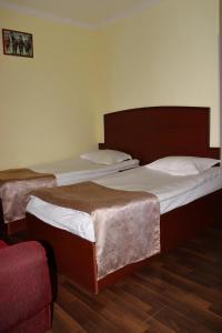 斯捷潘纳万RL Hotel的带红色椅子的客房内的两张单人床