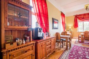吕德里茨Alte Villa Gästehaus的厨房配有木制橱柜和红色窗帘