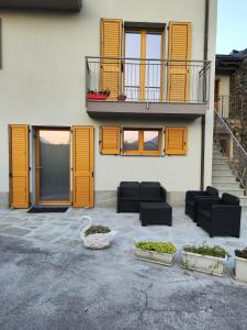 松德里奥Casa Vacanza Relax Sondrio的一座带橙色门和黑色家具的建筑和阳台