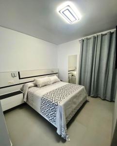 科尼尔-德拉弗龙特拉LOFT VILLALUCIA的一间带床的卧室,位于带窗帘的房间