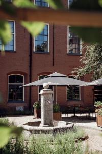 聚特芬Broederenklooster的前面有桌子和遮阳伞的砖砌建筑