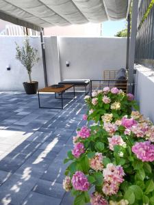 奥瑞比克Holiday home Maslina的庭院里设有两把长椅和粉红色的鲜花
