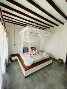 南威MITI Beach Bungalows的卧室配有白色的天蓬床。