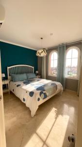 阿吉内金海滩Selena Luxury Monte Carrera的一间卧室设有一张大床,拥有蓝色的墙壁和窗户。