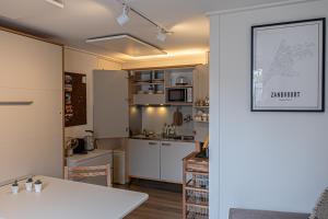 赞德沃特B&B de Drukkerij Zandvoort - luxury private guesthouse的厨房配有白色橱柜和白色桌子