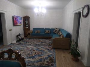 纳希切万House in Nakhchivan city, Azerbaijan的客厅配有蓝色的沙发和地毯。