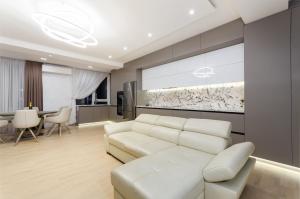 基希讷乌Luxury apartment close to the city centre的客厅配有白色的沙发和桌子