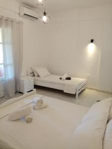 达西亚Pericles Apartment的白色的客房配有床和沙发