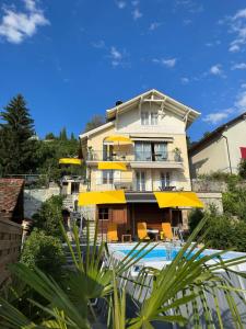 蒙特勒Villa Montreux的一座带游泳池和黄色遮阳伞的大房子