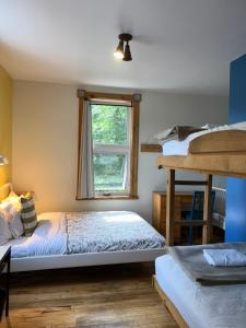 里维耶尔·杜·卢普Auberge Internationale de Rivière-du-Loup的一间卧室设有两张床和窗户。