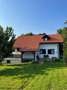 KriževciTomasova kuća的白色的房子,有红色的屋顶和院子