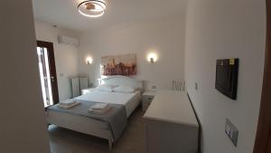托雷拉皮罗Villa Saponaro - Affittacamere的一间带两张床和电视的小卧室