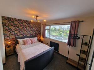 鲍内斯温德米尔Bowness - 3 Bed - Hot Tub House的一间卧室设有一张床和一个大窗户
