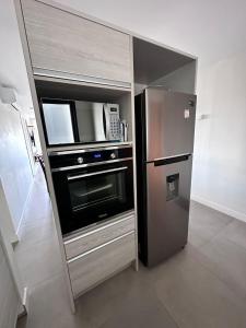 埃斯特角城Torre Green Life FullAmenities的厨房配有不锈钢冰箱和微波炉。