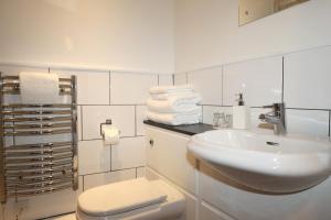 赫默尔亨普斯特德The Olde Kings Arms的浴室配有盥洗盆、卫生间和毛巾。