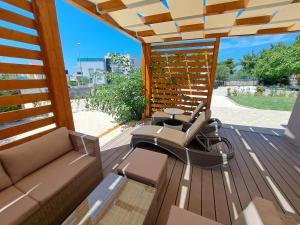 布罗达里卡Holiday house SeaDream - 50 meters from the sea的露台配有沙发和椅子,位于甲板上