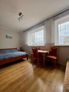 亚斯塔尔尼亚Willa Dominik 2的卧室配有一张床和一张桌子及椅子