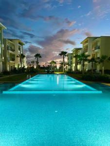 西迪拉哈尔Cosy Apartment with sea view的一座大型蓝色游泳池,位于部分建筑前