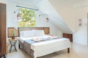 卢纳将军城Kalipay Resort Siargao的一间卧室配有一张床,上面有两条毛巾