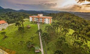 约恩维利Hotel Fazenda Dona Francisca的享有山上树木建筑的空中景致