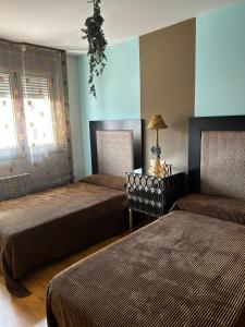 康达La Casa de Blanca的一间卧室设有两张床和一张桌子上的台灯。