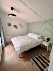 埃梅Le Patio d’Eymet的卧室配有白色的床和桌子