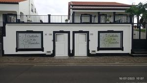 拉日什Cantinho dos Remédios的一条白色的建筑,在街上有两扇门