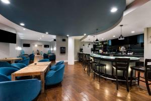 圣安吉洛Suburban Studios的一间设有蓝色椅子的餐厅和一间酒吧