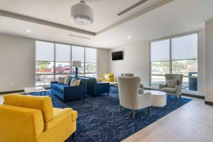 新里奇港Comfort Inn & Suites New Port Richey Downtown District的客厅配有黄色家具和蓝色沙发