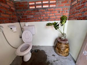 Bagan Teochew吉胆岛 潮汐民宿 Pulau Ketam Tide Homestay的一间带卫生间的浴室和一个植物花瓶