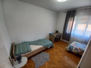 弗尔博夫斯科Kuca za odmor "MARIJA"的一间卧室设有两张床、一张桌子和一个窗口。