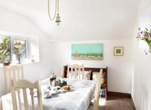 Saint BlazeyMiddleway Cottage的一间配备有白色桌椅的用餐室