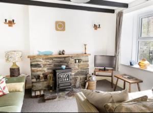 Saint BlazeyMiddleway Cottage的客厅设有石制壁炉和电视。